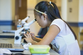 student using a microscope