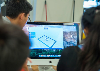 students looking at monitor with 3d software on it