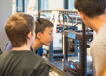 students looking at 3d printer