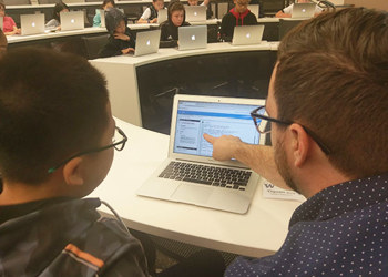 student and instructor looking at laptop